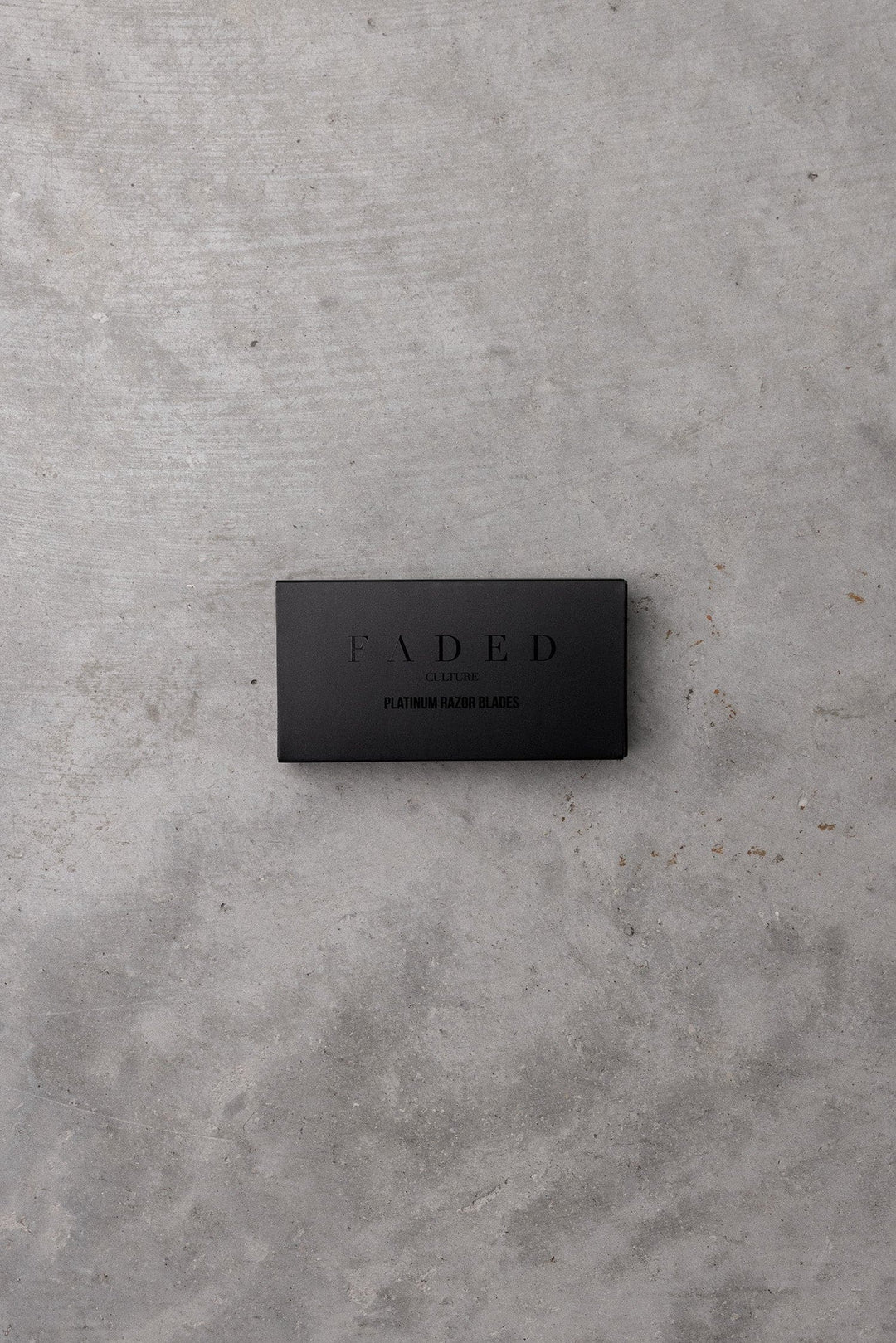 Black rectangular box with 'FADED' branding on a gray concrete surface