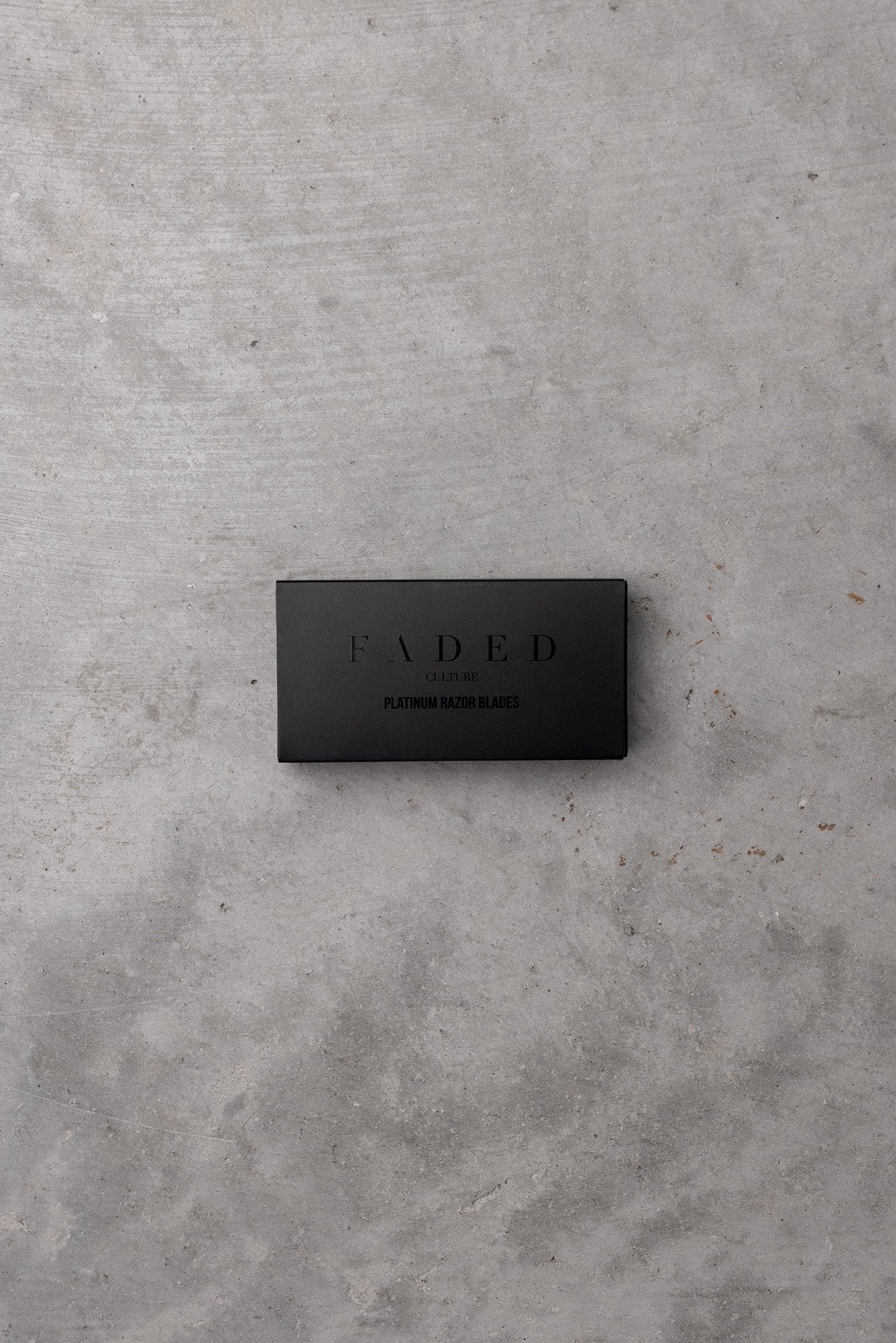 Black rectangular box with 'FADED' branding on a gray concrete surface