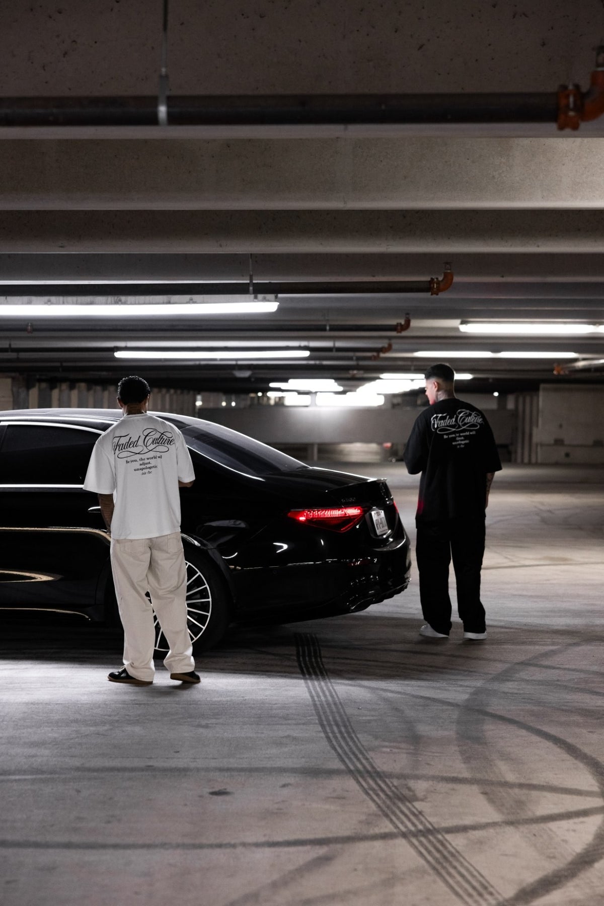 Faded Culture Unapologetic tee in black and white — back view, parking garage #color_black
